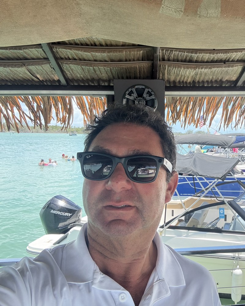 Captain Evan, owner and lead captain of Sand Dollar Shelling, under the tiki boat's thatched roof